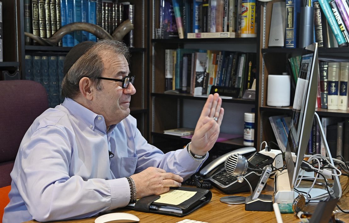 Rabbi Mitchell Wohlberg of Beth Tfiloh in Baltimore waves to members of his congregation before giving instruction on how to conduct Passover rituals and seders during a "Lunch and Learn" online conference session from his home study on March 26, 2020. 