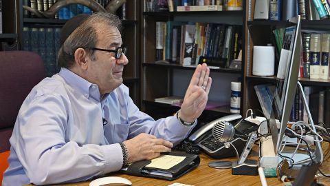 Rabbi Mitchell Wohlberg of Beth Tfiloh in Baltimore waves to members of his congregation before giving instruction on how to conduct Passover rituals and seders during a "Lunch and Learn" online conference session from his home study on March 26, 2020.