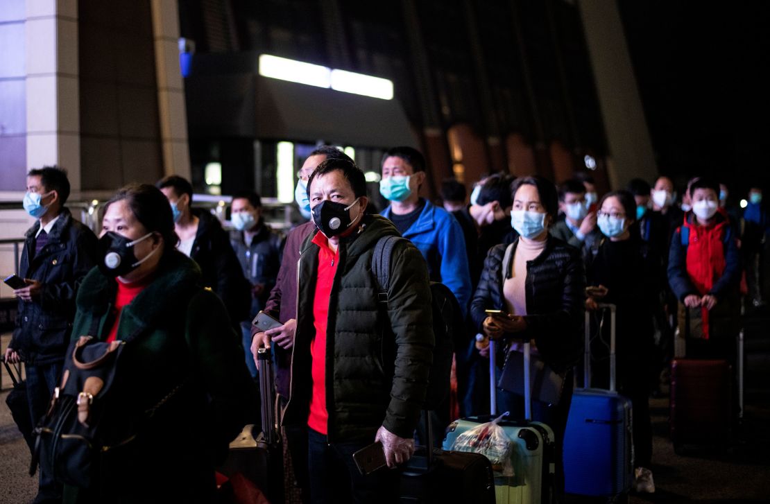 Passengers wear facemasks as they form a queue at the Wuhan Wuchang Railway Station in Wuhan, early on April 8, as they prepare to leave the city for the first time in more than ten weeks.