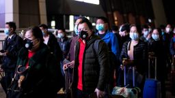 Passengers wear facemasks as they form a queue at the Wuhan Wuchang Railway Station in Wuhan, early on April 8, 2020, as they prepare to leave the city in China's central Hubei province.