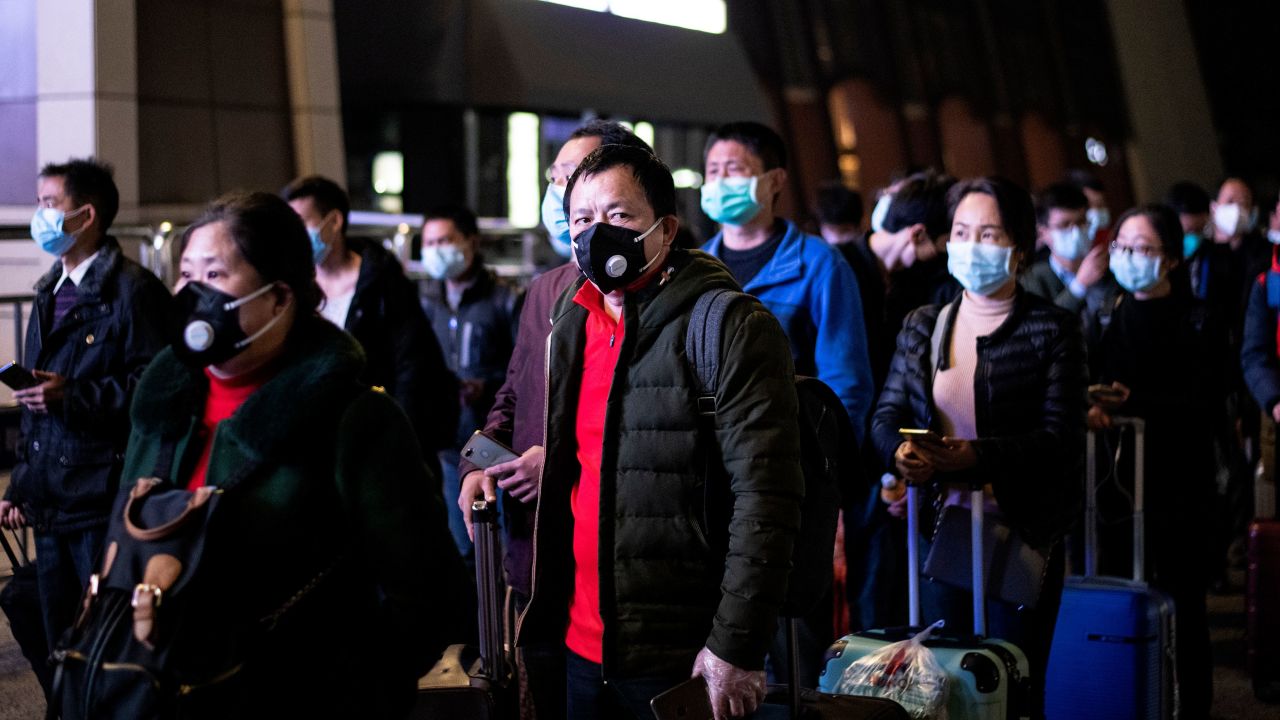 Passengers wear facemasks as they form a queue at the Wuhan Wuchang Railway Station in Wuhan, early on April 8, as they prepare to leave the city for the first time in more than ten weeks.