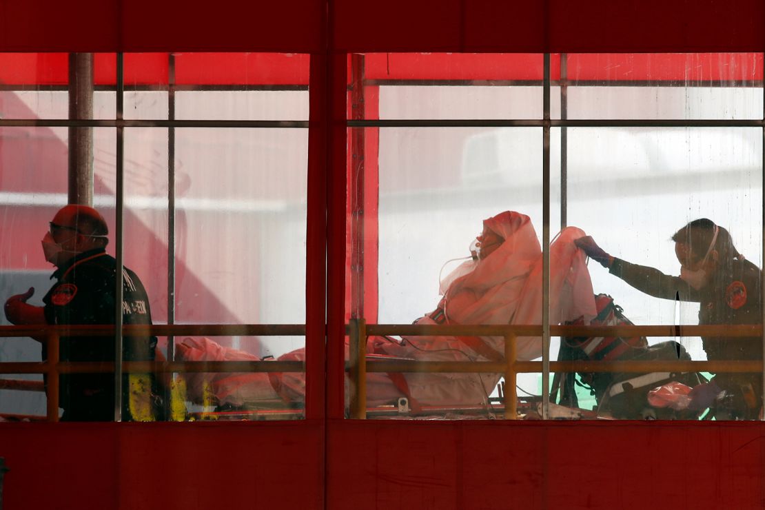 Emergency medical technicians wheel a patient into Elmhurst Hospital Center's emergency room in New York City.