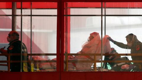 Emergency medical technicians wheel a patient into Elmhurst Hospital Center's emergency room in New York City.