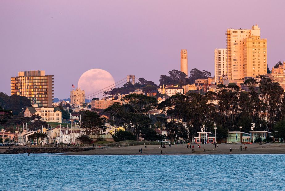The full moon rises above the horizon in San Francisco, California.