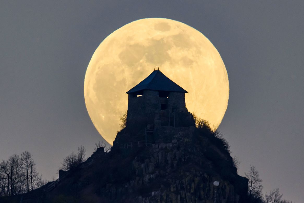 The full moon rises above Salgo castle in Hungary. 