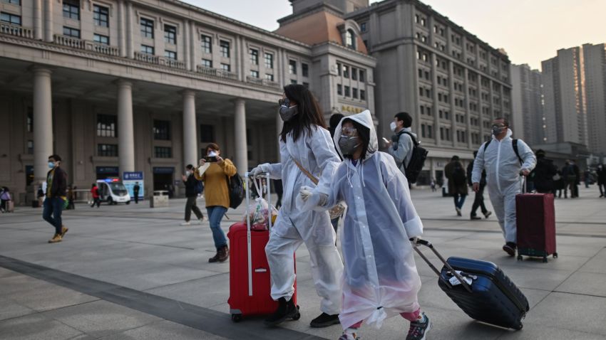 People wearing protective clothing and masks arrive at Hankou Railway Station in Wuhan, to board one of the first trains leaving the city in China's central Hubei province early on April 8, 2020. - Chinese authorities lifted a more than two-month ban on outbound travel from the city where the global pandemic first emerged. (Photo by Hector RETAMAL / AFP) (Photo by HECTOR RETAMAL/AFP via Getty Images)