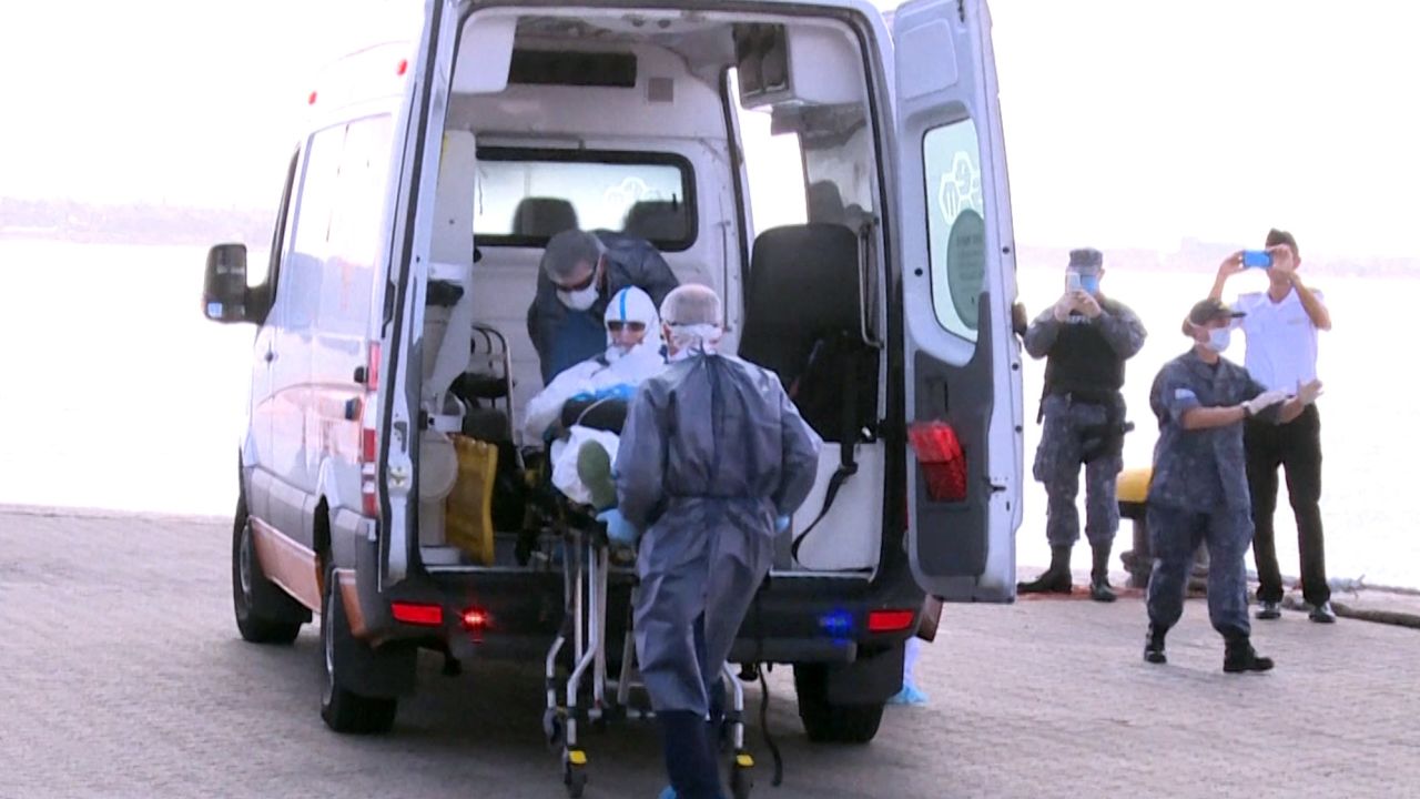 A 75-year-old Australian passenger suffering from pneumonia is seen being evacuated from the Greg Mortimer cruise liner to an ambulance in Montevideo on April 3, 2020.