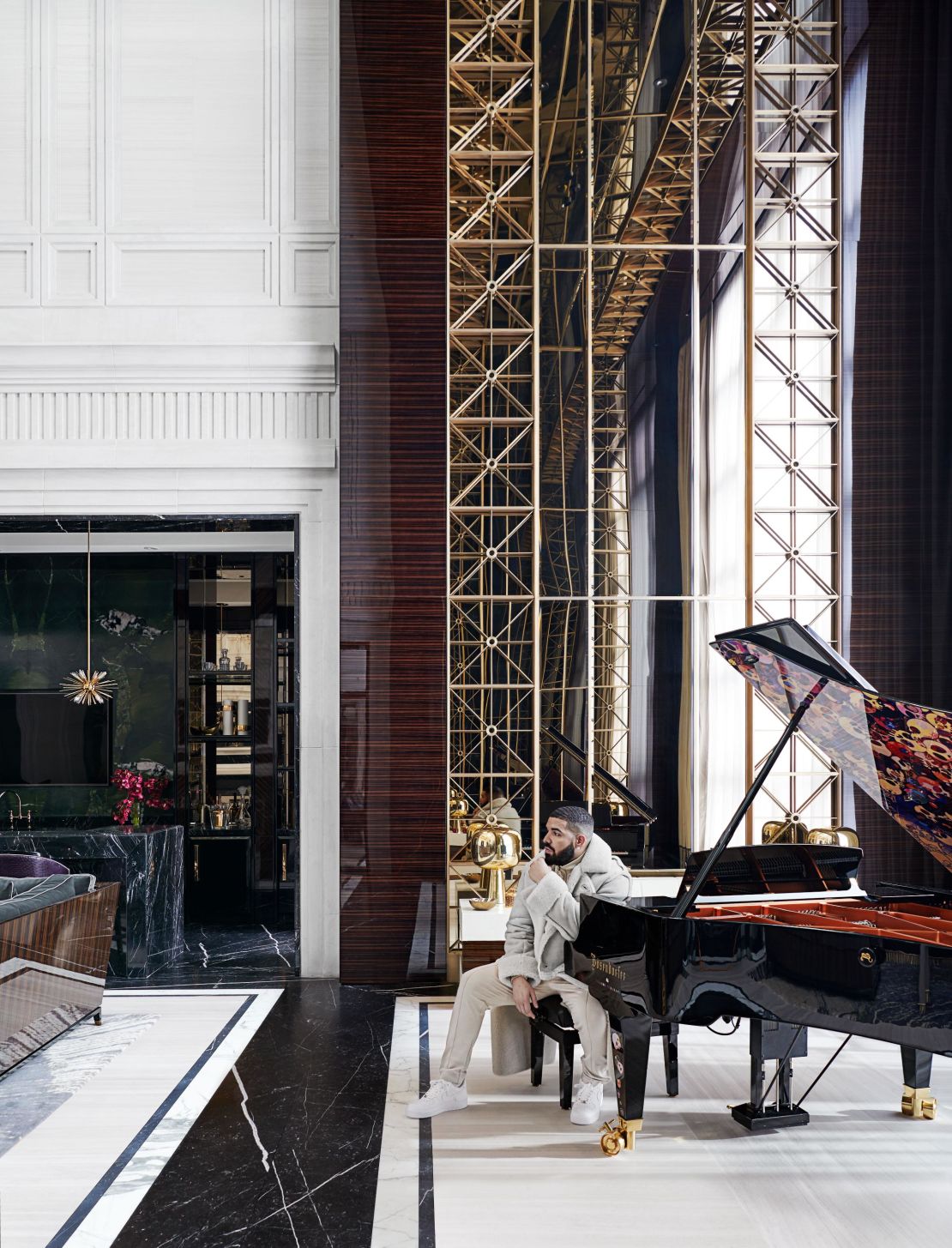 Drake in his Toronto home next to a bespoke B?sendorfer concert grand piano, designed by Ferris Rafauli and Takashi Murakami. 