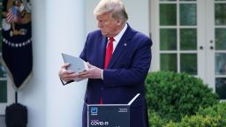US President Donald Trump holds a 5-minute test for COVID-19 from Abbott Laboratories during the daily briefing on the novel coronavirus, COVID-19, in the Rose Garden of the White House in Washington, DC, on March 30, 2020.