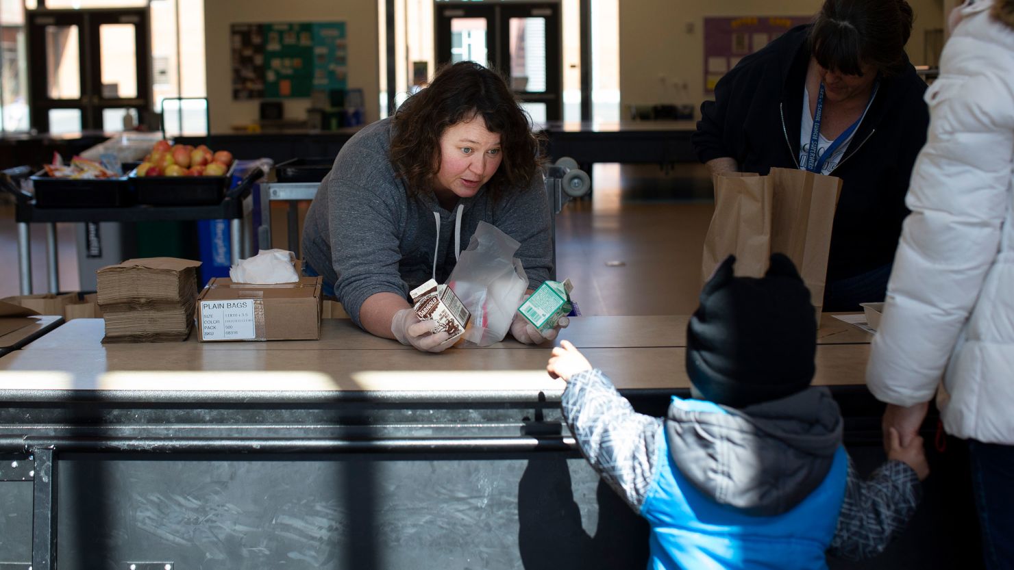 SEATTLE, WA - MARCH 18: Christy Cusick hands out free school lunches to kids and their parents at Olympic Hills Elementary School on March 18, 2020 in Seattle, Washington. As a result of all schools in Washington state being closed due to the COVID-19 outbreak until at least April 27th, Seattle Public Schools is providing carry-out meals to students during lunch hours. (Photo by Karen Ducey/Getty Images)