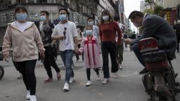 Residents walk along a retail street in Wuhan in central China's Hubei province on Wednesday, April 8, 2020. The city of 11 million people was locked down Jan. 23 to contain the coronavirus. (AP Photo/Ng Han Guan)