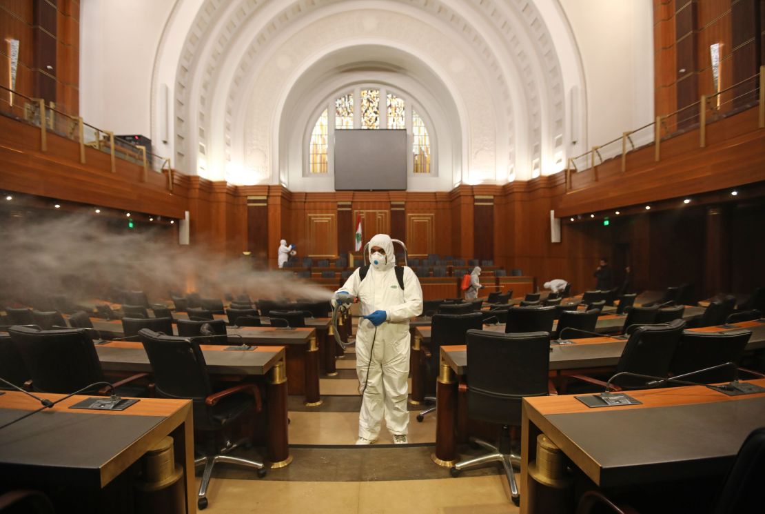 Sanitary workers disinfect the desks and chairs of the Lebanese Parliament on March 10.