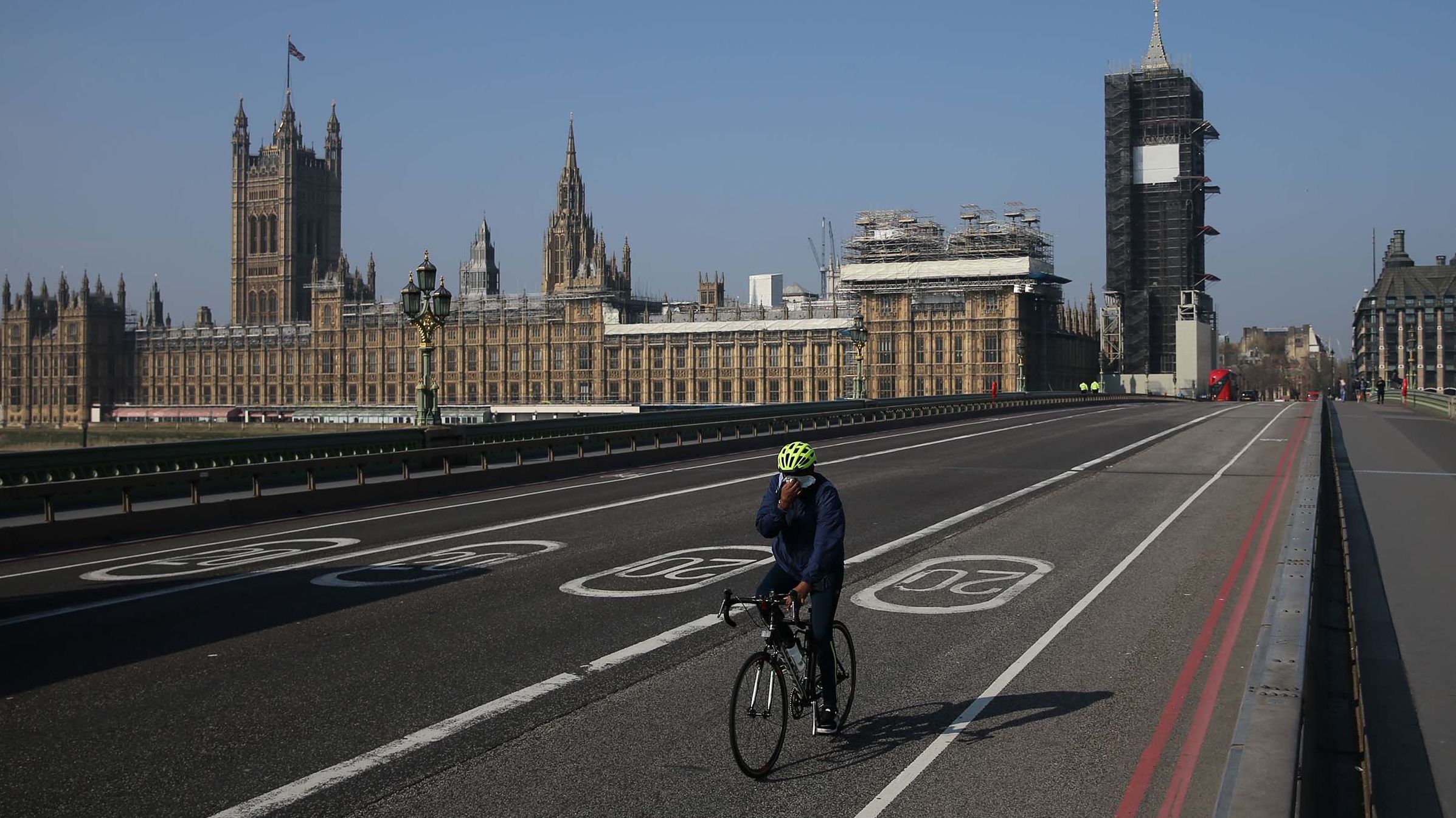 A cyclist crosses a near-empty Westminster Bridge with the Houses of Parliament in the background in central London on April 9, 2020. - British Prime Minister Boris Johnson on Thursday began a fourth day in intensive care "improving" in his battle with coronavirus, as his government prepared to extend a nationwide lockdown introduced last month. (Photo by ISABEL INFANTES/AFP via Getty Images)