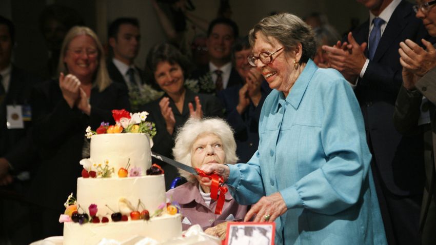 Lesbian rights pioneers Del Martin (C) and Phyllis Lyon (2ndR) cut their wedding cake after getting married at city hall in San Francisco, CA, on June 16, 2008. The couple wore the same pastel-colored pantsuits they donned four years ago when they wed the first time. Martin and Lyon were among the first of thousands of same-sex couples who plan to wed after the California Supreme Court granted lesbian and gay couples the constitutional right to marry. AFP PHOTO / Ryan ANSON  (Photo credit should read Ryan Anson/AFP via Getty Images)