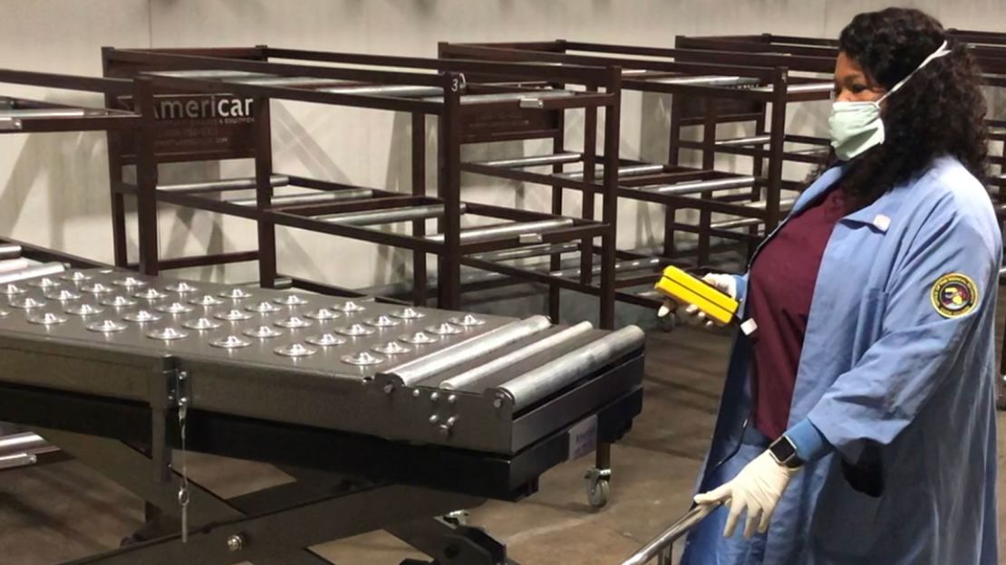 A doctor with the Cook County Medical Examiner's Office testing the device used to weigh and transfer bodies into their respective racks.