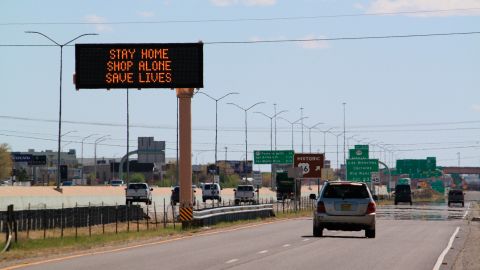 Flashing highway message boards along Interstate 25 in Albuquerque, New Mexico, on April 9 urge people in both English and Spanish to stay home amid the coronavirus outbreak.