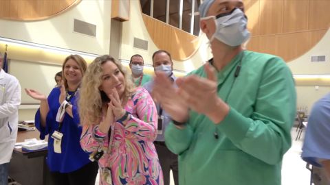 A line of staff members and medical center leadership cheered their first Covid-19 patient on after he was discharged to go home and recover.