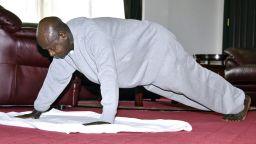 In this handout photo provided by Uganda's Presidential Press Unit, Uganda's President Yoweri Museveni performs push-ups in a video released to the public via the president's social media accounts, at State House in Entebbe, Uganda Thursday, April 9, 2020. Uganda's 75-year-old president has released a homemade exercise video to show skeptical countrymen that one can stay in shape under the lockdown that has been implemented to curb transmission of the new coronavirus. (Uganda Presidential Press Unit via AP)