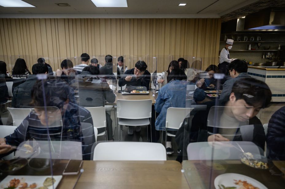 Employees of Hyundai Card, a credit card company, sit behind protective screens as they eat in an office cafeteria in Seoul, South Korea, on April 9, 2020.
