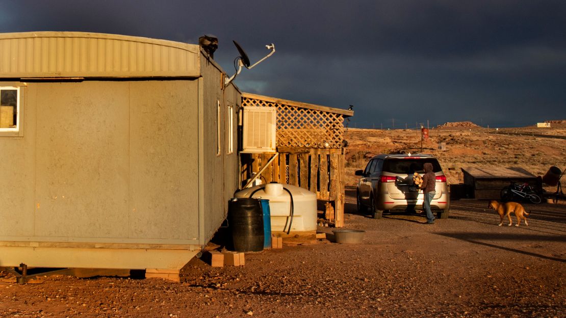 A Navajo woman carries wood to heat her rural mobile home during the coronavirus pandemic on March 27, 2020, in Cameron, Arizona.