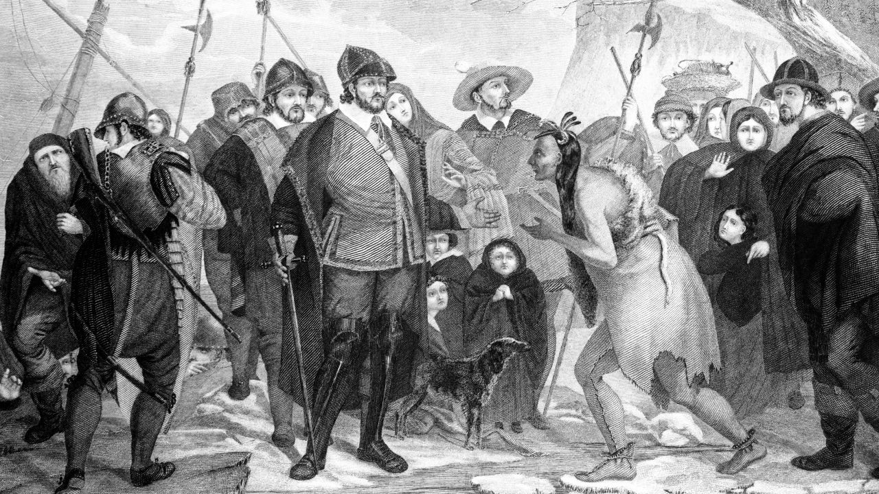 An illustration of Myles Standish and Pilgrims greeting a Native American at Plymouth Rock in 1620.
