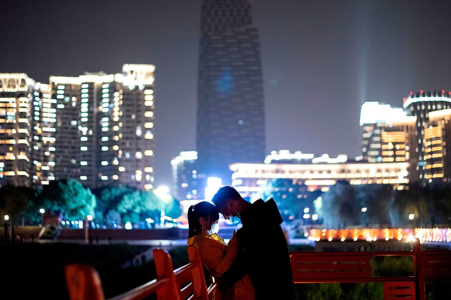 A couple stands in a park along the Yangtze River in Wuhan, China.