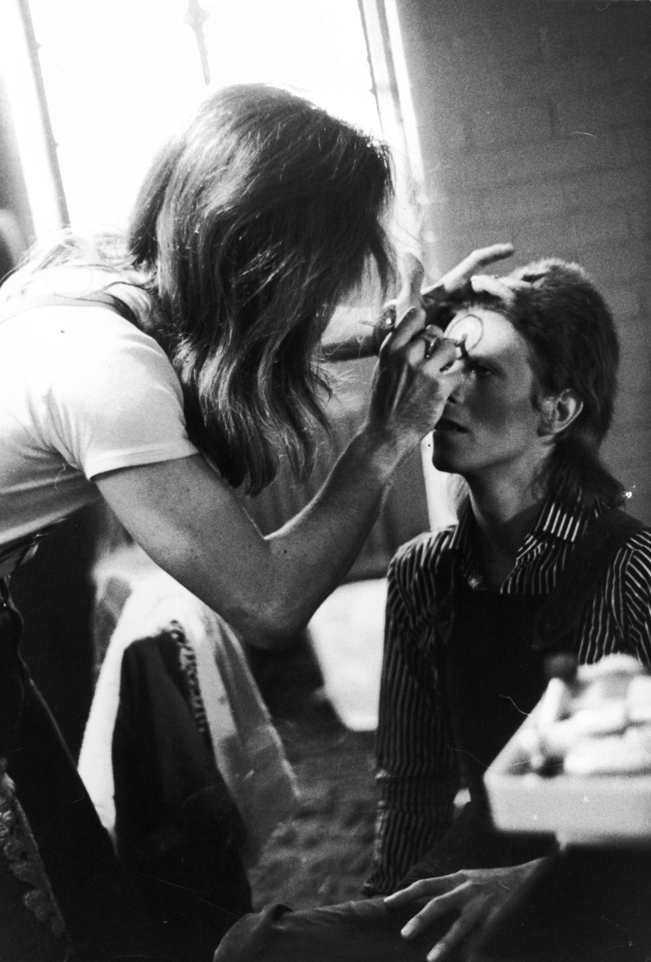 Make-up artist Pierre La Roche prepares David Bowie for a performance as Aladdin Sane, 1973.