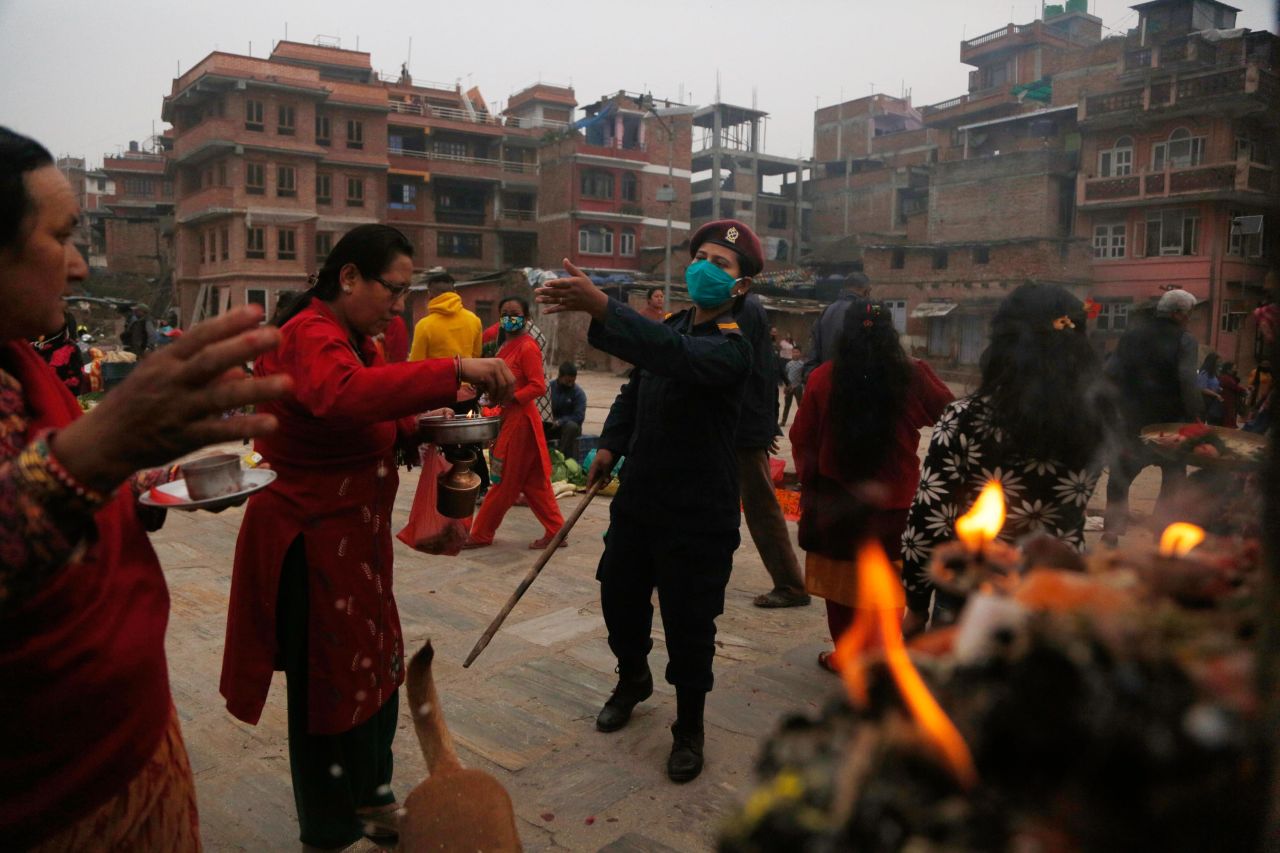 A police officer requests that people return to return to their homes during a gathering that marked the Bisket Jatra festival in Bhaktapur, Nepal.