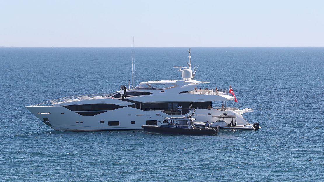 A police boat pulls over a yacht sailing in the waters of Australia while unnecessary travel is prohibited.