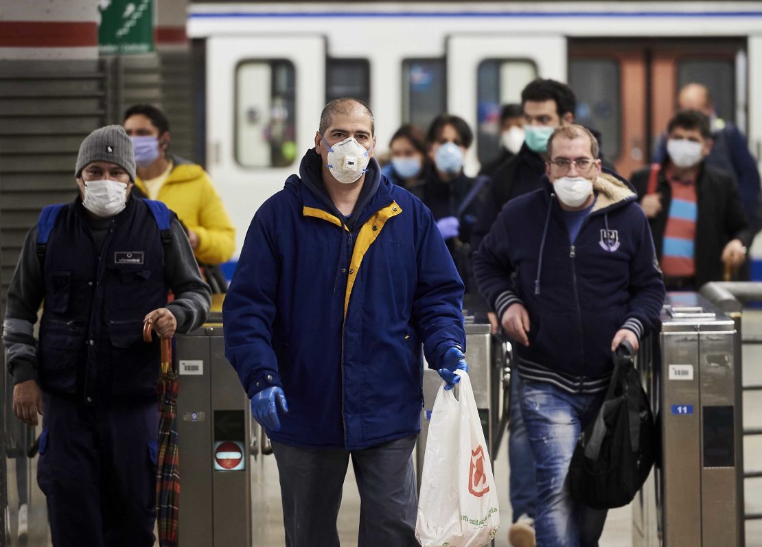 Spanish workers wear masks leaving the subway on April 13, in Madrid.  
