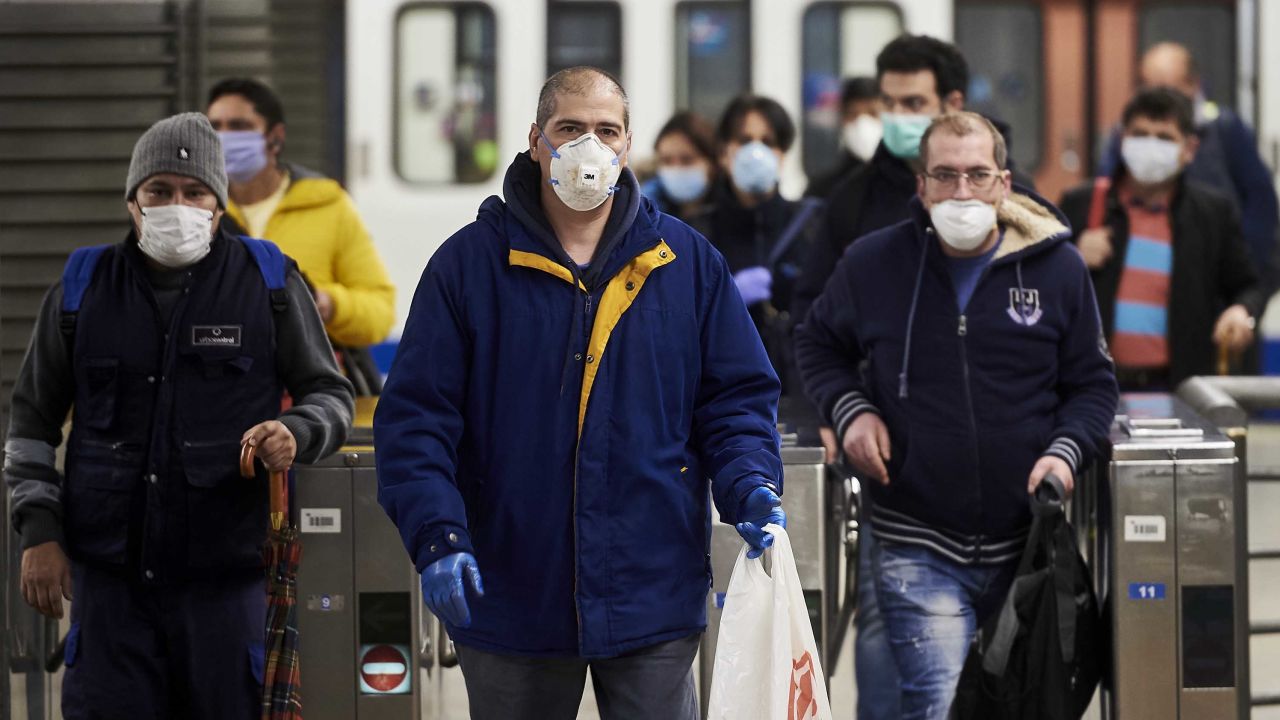 Spanish workers wear masks leaving the subway on April 13, in Madrid.  