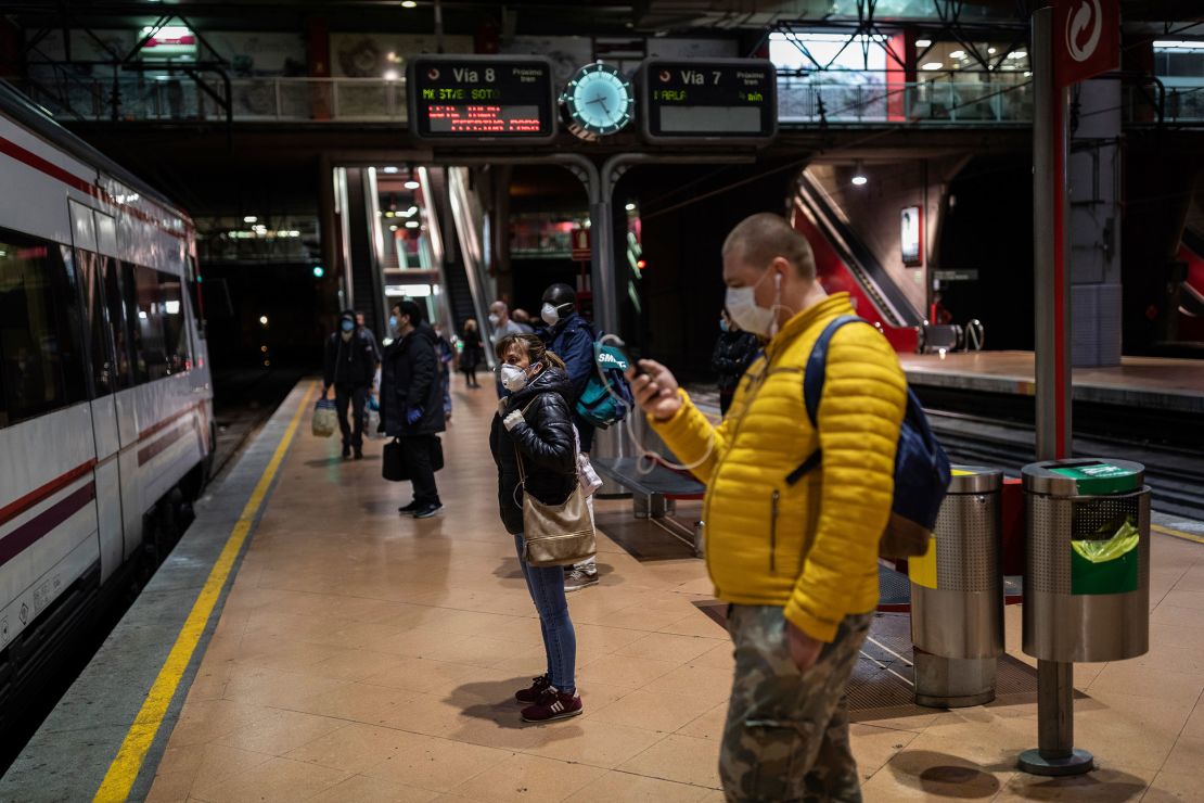 Commuters wearing face masks to protect against coronavirus at the platform of Atocha train station in Madrid, Spain, on Monday.