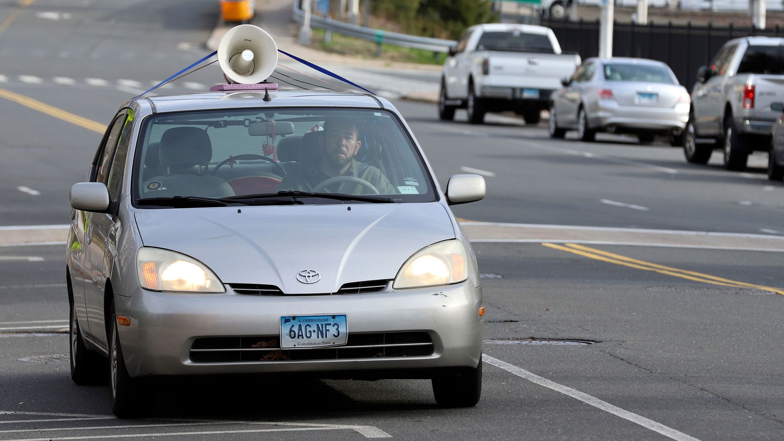 A person drives a car with a megaphone attached to the roof to protest Immigration and Customs Enforcement in Hartford, Connecticut, on April 2.