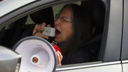 RETRANSMISSION TO CORRECT ID FROM JESSE RIVERA TO DEBRA COHEN - Debra Cohen speaks into a megaphone held out a car window in a protest against Immigration and Customs Enforcement in Hartford, Conn., Thursday, April 2, 2020. The rally coincides with a lawsuit filed by lawyers to seek the release of immigrants in ICE custody who are at risk of contracting COVID-19. (AP Photo/Chris Ehrmann)