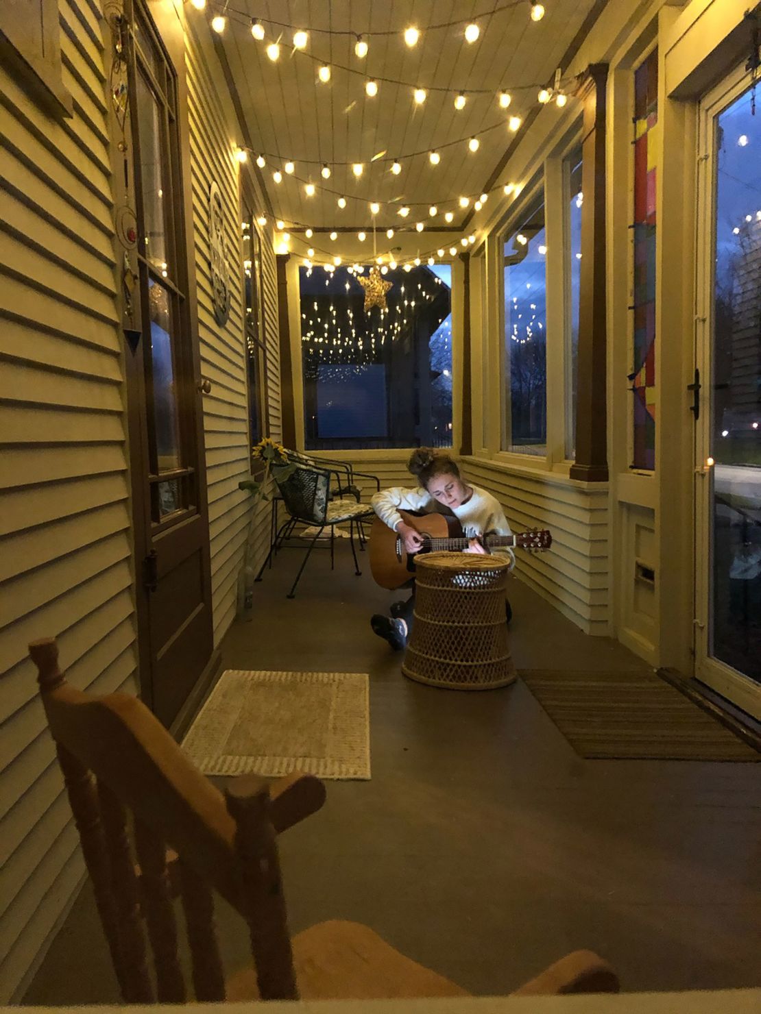 Steve Schneider's 18-year-old daughter plays her guitar on their porch in Sheboygan, Wisconsin
