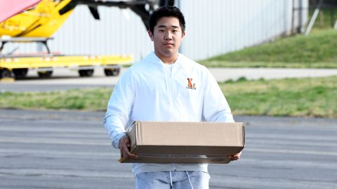 Kim carries essential supplies to his plane. He hopes to attend the US Naval Academy after high school. 