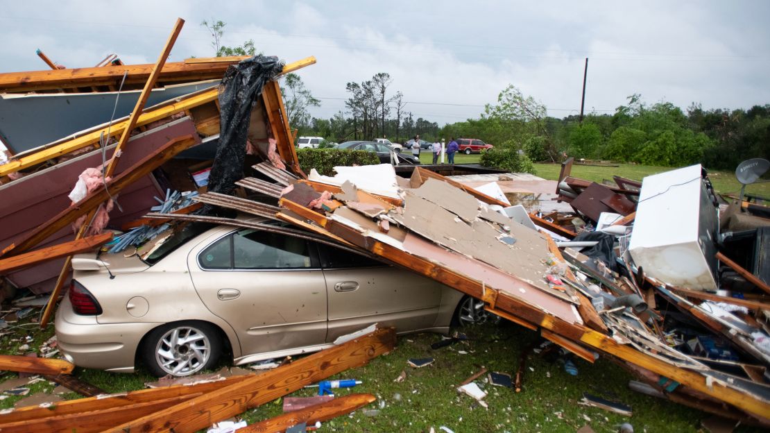 A car is partially covered by the debris of a house torn apart in Livingston, South Carolina.
