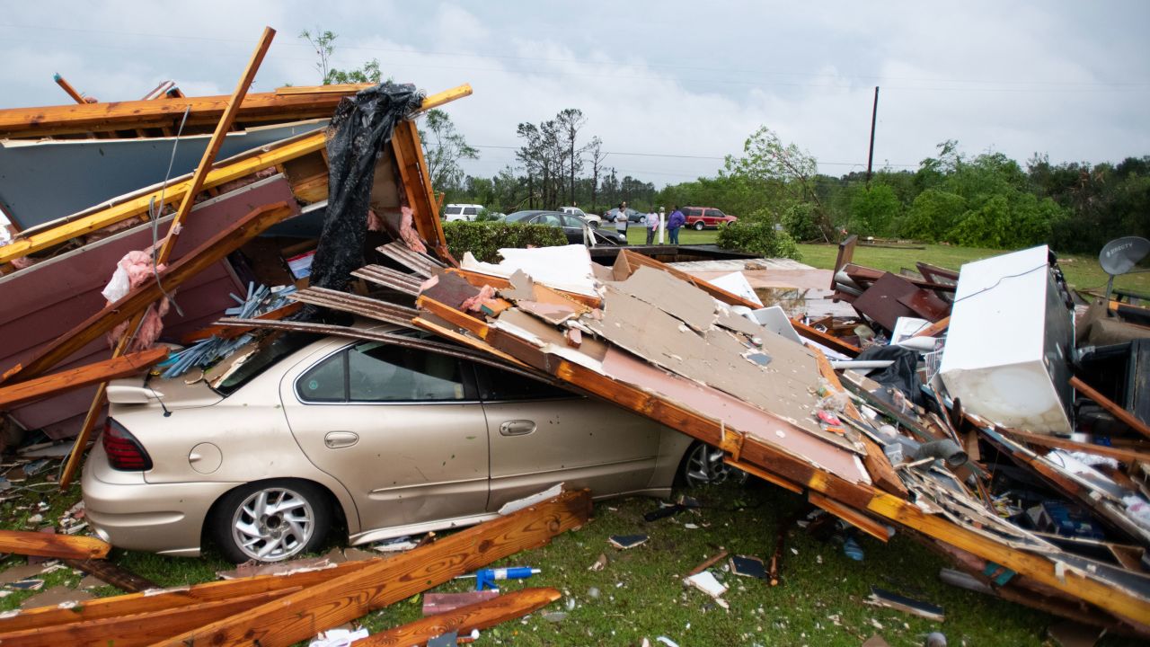 A car is partially covered by the debris of a house torn apart in Livingston, South Carolina.