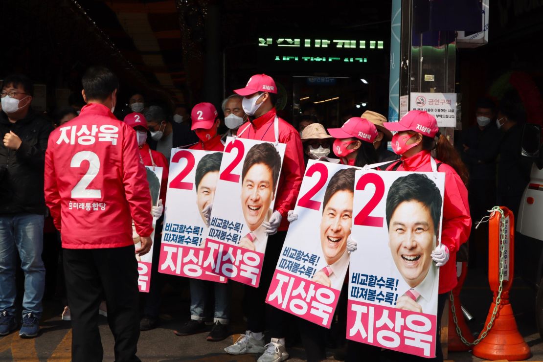 Campaign workers for the conservative United Future Party hold posters at a market in Dongdaemun in Seoul, South Korea, on April 7.