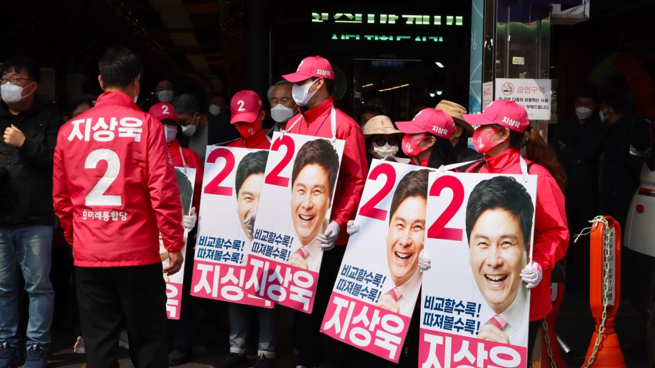 Campaign workers for the conservative United Future Party hold posters at a market in Dongdaemun in Seoul, South Korea, on April 7.