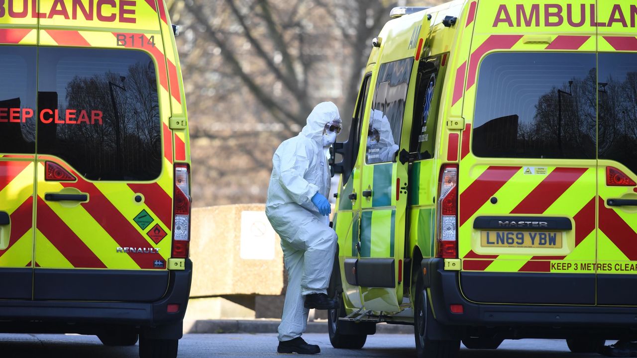 A member of the ambulance service wearing personal protective equipment is seen leading a patient (unseen) into an ambulance at St Thomas' Hospital in London on March 24, 2020. - Britain's leaders on Tuesday urged people to respect an unprecedented countrywide lockdown, saying that following advice to stay at home would stop people dying of coronavirus. (Photo by DANIEL LEAL-OLIVAS / AFP) (Photo by DANIEL LEAL-OLIVAS/AFP via Getty Images)