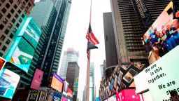 The US flag is seen at half-mast at the almost deserted Times Square on April 13, 2020 in New York City. - New York's governor declared April 13, 2020 that the "worst is over" for its coronavirus outbreak providing the state moves sensibly, despite reporting its death toll had passed 10,000. Andrew Cuomo said lower average hospitalization rates and intubations suggested a "plateauing" of the epidemic and that he was working on a plan to gradually reopen the economy. (Photo by Johannes EISELE / AFP) (Photo by JOHANNES EISELE/AFP via Getty Images)