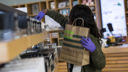 An employee wearing gloves gathers items for a pick-up order at the Harborside dispensary in Oakland, California, on Monday, March 23, 2020. California's shelter-in-place order vastly expands mandates put in place across the San Francisco Bay Area. It allows people in the most populous U.S. state to leave their homes for needed items like groceries and medicine, while otherwise requiring that they limit their social interactions. Photographer: David Paul Morris/Bloomberg via Getty Images