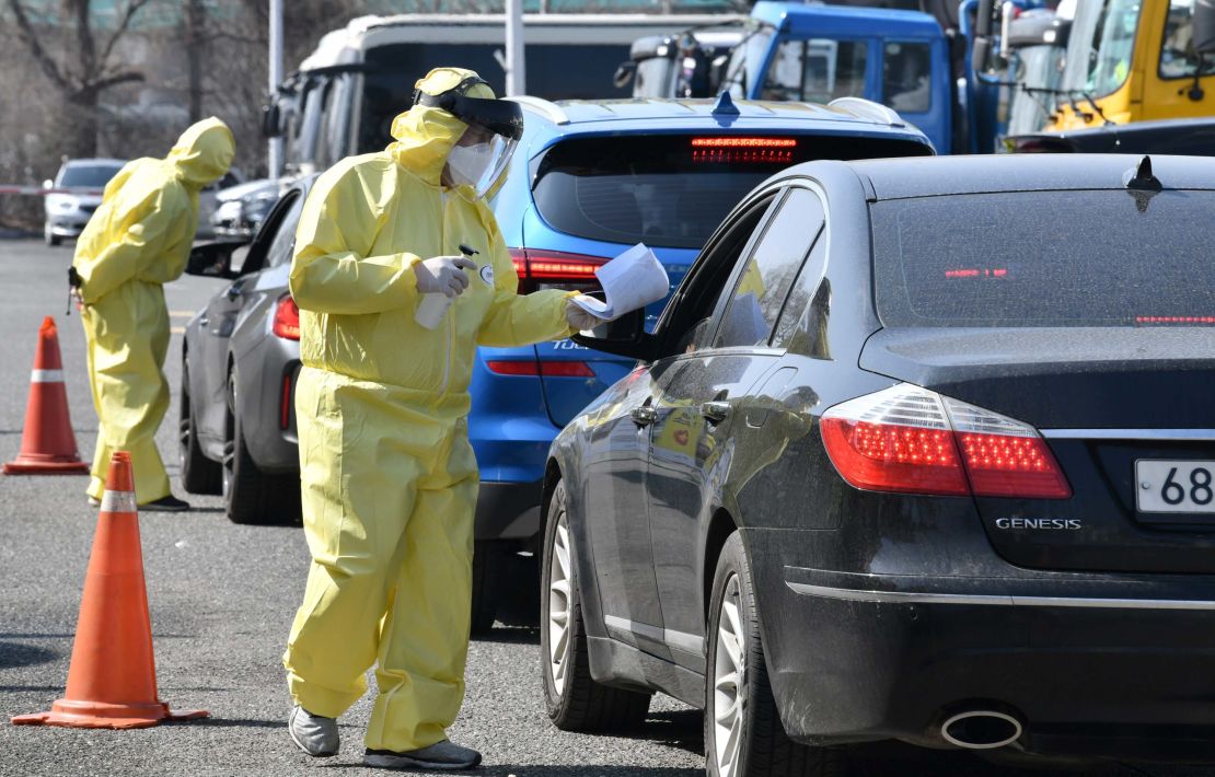 Medical staff guide drivers with suspected coronavirus symptoms at a drive-thru testing facility in Goyang, north of Seoul, on February 29.