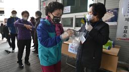 A South Korean woman wears plastic gloves amid concerns over the Covid-19 coronavirus before casting her ballot for the parliamentary elections at a polling station in Seoul on April 15, 2020.