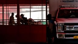 EMTs wearing protective equipment carry a patient into Elmhurst Hospital Center in the Queens borough of New York, U.S., on Tuesday, April 14, 2020. If the city is to reduce and maintain low-level transmission, testing will be crucial to identify new cases and trace patients' social contacts so that they may be isolated or quarantined, officials have said. 