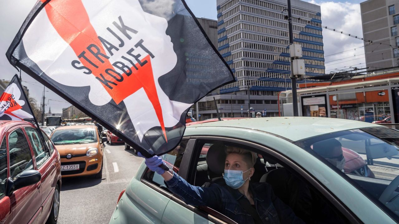 Protesters wave flags and hold posters emblazoned with a red lightning bolt.