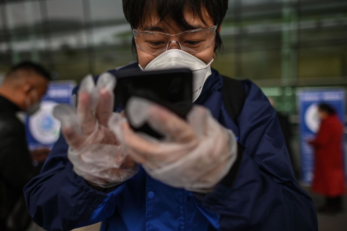 A passenger uses a smartphone while scanning a Wuhan city health QR code before entering Tianhe Airport in Wuhan on April 11.