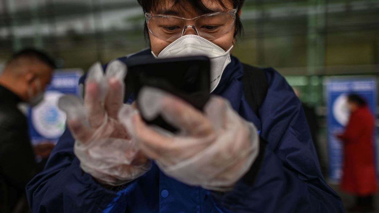 A passenger uses a smartphone while scanning a Wuhan city health QR code before entering Tianhe Airport in Wuhan on April 11.
