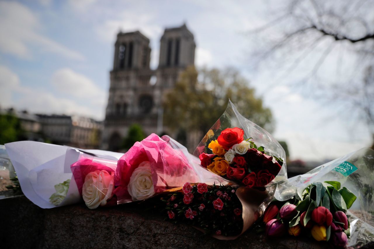 Flowers are laid on a bridge in front of Notre Dame on April 17, 2019.